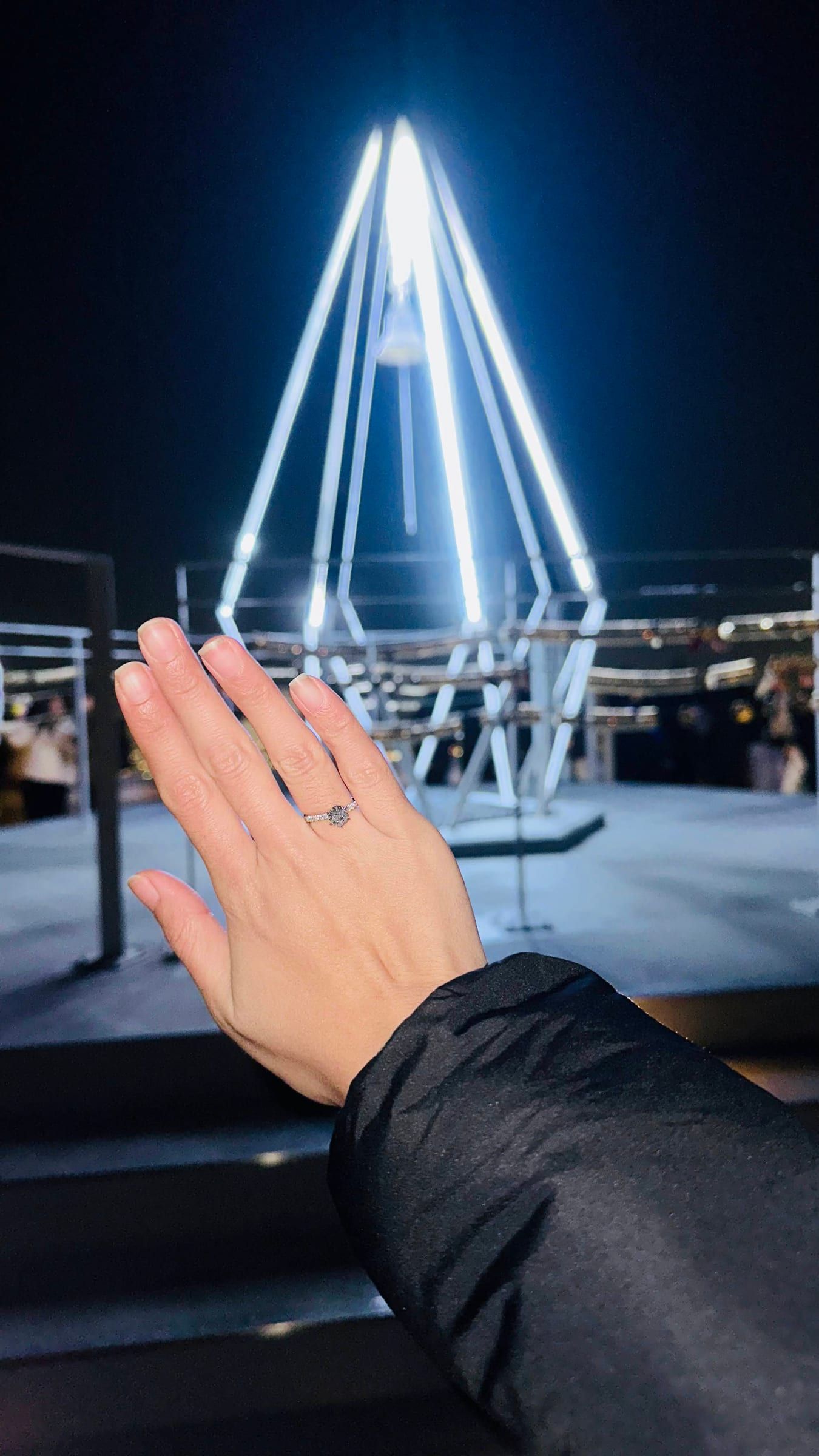 Anna's hand with the ring, the lit bell tower behind